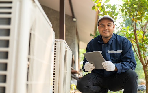 HVAC contractor in a blue shirt and white gloves providing AC Maintenance for a San Antonio home.